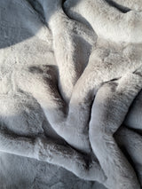 ONE Preevay's Faux Rabbit Fur Throw in Dramatic Gray. Inspired by Fernando Botero, crafted from Ultra Premium Faux Rabbit Fur. Hypoallergenic, cruelty-free, and lined with elegant velvet for refined warmth over the sofa layout.....