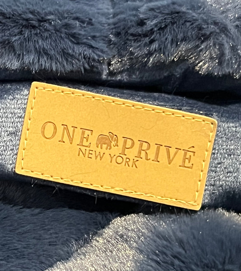 Ribbed Faux Rabbit & Velvet Blanket Collection by One Preevay Luxury Home Furnishings & Decor. Inspired by the regal Robe Royal, each hand-stitched piece features premium cruelty-free faux rabbit fur with elegant velvet underside, available in four luxurious colors: Elegant Black, Warm Beige, Classic Navy, and Dramatic Gray. Sizes: Twin (60" x 90"), Queen (90" x 90"). Hypoallergenic, soothing ribbed design for relaxation and easy care. Cruelty-free luxury, unmatched craftsmanship and detail in Blue...