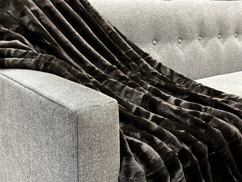 Ribbed Faux Rabbit & Velvet Blanket Collection by One Preevay Luxury Home Furnishings & Decor. Inspired by the regal Robe Royal, each hand-stitched piece features premium cruelty-free faux rabbit fur with elegant velvet underside, available in four luxurious colors: Elegant Black, Warm Beige, Classic Navy, and Dramatic Gray. Sizes: Twin (60" x 90"), Queen (90" x 90"). Hypoallergenic, soothing ribbed design for relaxation and easy care. Cruelty-free luxury, unmatched craftsmanship and detail in black..