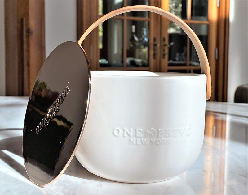 Indulge in the Bergamot and Clove Perfumed Estate Candle from One Preevay. Handcrafted with premium essential oils and soy wax, it features a stunning porcelain bowl with a silver-plated lid and leather strap. Elevate your ambiance with style and love