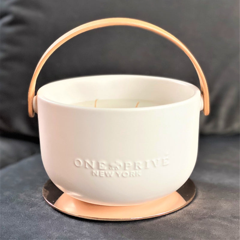 Indulge in the Bergamot and Clove Perfumed Estate Candle from One Preevay. Handcrafted with premium essential oils and soy wax, it features a stunning porcelain bowl with a silver-plated lid and leather strap. Elevate your ambiance all year around 